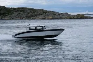 cabineboot op open water bij rotsen