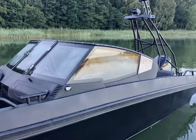 snelboot op rustig water bij boomrijke oever