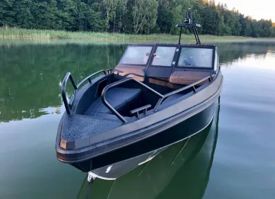 snelboot op rustig water bij bosrand