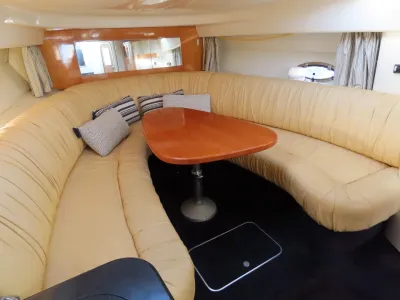 Salondeel met gebogen beige zitbank en houten tafel
