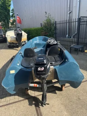 blauwe open boot met buitenboordmotor op trailer