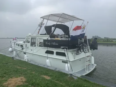 Motorjacht aangemeerd langs graswal