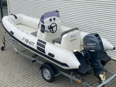 witte rib-boot op trailer met buitenboordmotor