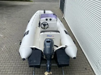 rubberboot op bestrating naast een loods