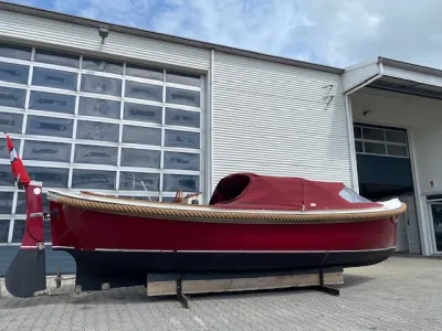 rode klassieke sloep op land voor loods