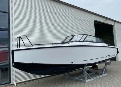 wit motorjacht op bok naast loods