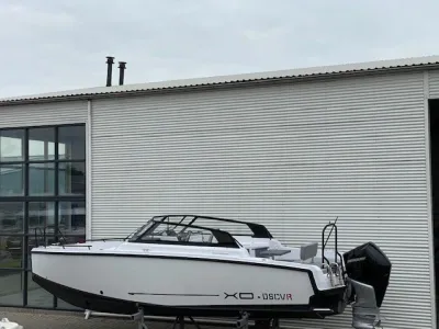 witte sportboot op bokken bij loods