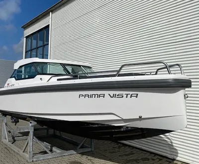 wit motorjacht op stelling naast loods