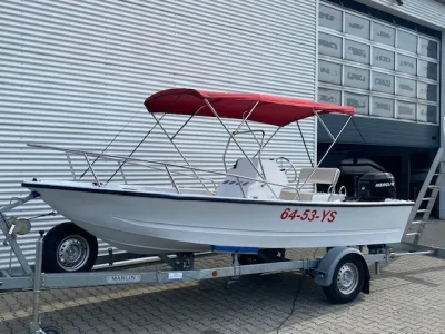 kleine visboot op trailer met rood bimini