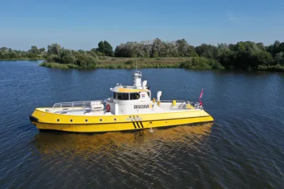 gele boot op rivier bij groene oever