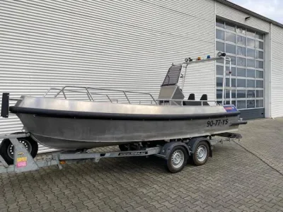 aluminium reddingsboot op trailer bij loods