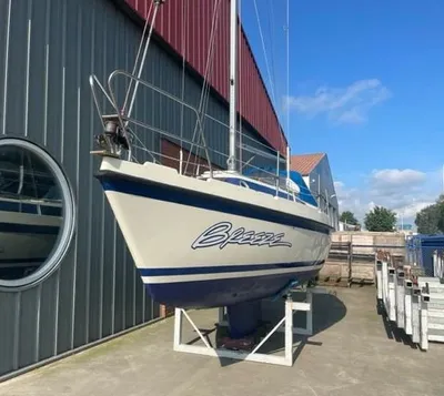 kajuitzeilboot op bok bij loods