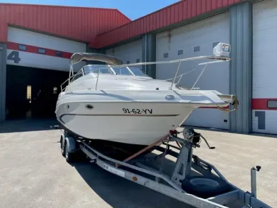 wit motorjacht op trailer voor loods