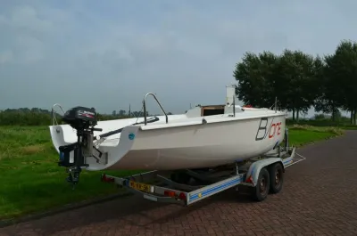 zeilboot op trailer bij gras en bomen