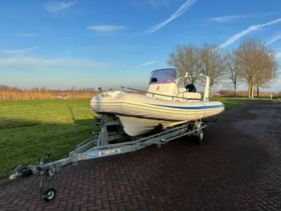 Sportboot op trailer bij weg en gras