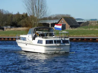 wit motorjacht varend op rivier