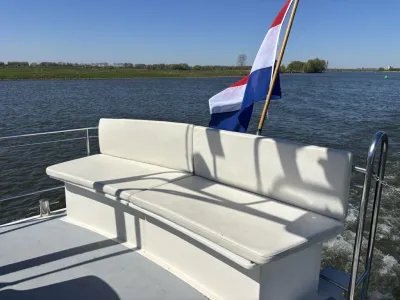 wit zitbankje op achterdek met vlag