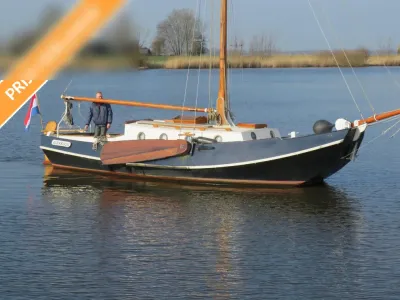 zeilboot op rustig water met persoon op dek