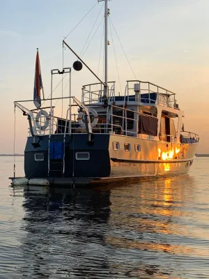 stalen trawler op rustig water bij zonsondergang