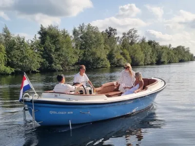 vier personen op een sloep op rustig water