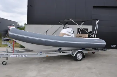 grijze RIB op trailer bij bedrijfsgebouw