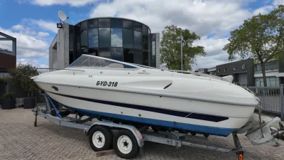 witte speedboot op trailer bij gebouw