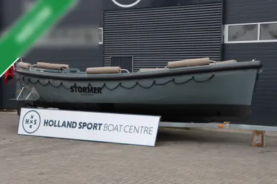 grijze open boot op trailer bij gebouw