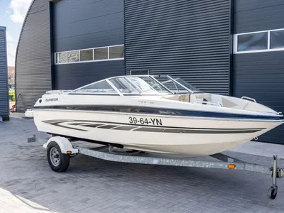 witte speedboot op trailer bij loods