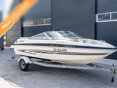 witte speedboot op trailer bij loods