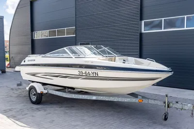 witte speedboot op trailer bij loods