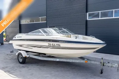 witte speedboot op trailer bij loods
