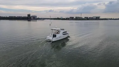 wit motoryacht op water met stadsachtergrond