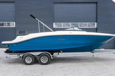 blauwe speedboot op trailer voor loods