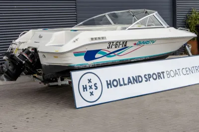Witte speedboot op trailer bij gebouw