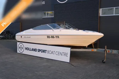 witte sportboot op trailer voor bedrijfspand