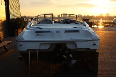 achterkant van een sportboot bij zonsondergang