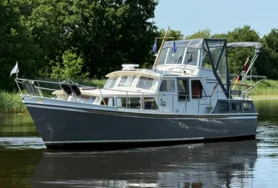 motorjacht op kalm water bij groene oever