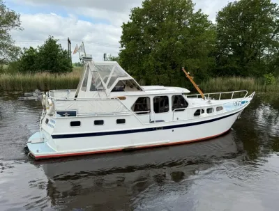witte motorkruiser op kanaal bij riet