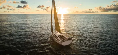 zeiljacht op open zee bij zonsondergang