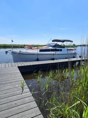 Motorboot afgemeerd aan houten steiger