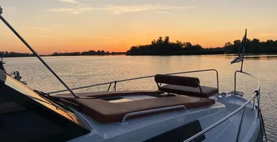 boeg van motorboot bij zonsondergang