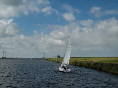 zeilboot op kanaal naast grasland