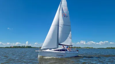 zeilboot op open water met blauwe lucht