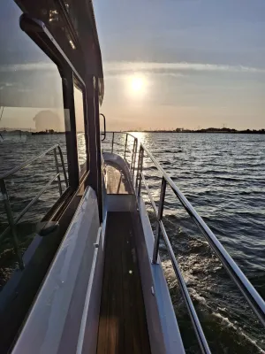 Zijdek en reling van motorjacht bij zonsondergang