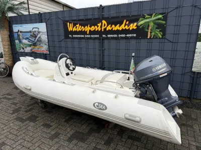 witte ribboot met buitenboordmotor op parkeerplaats
