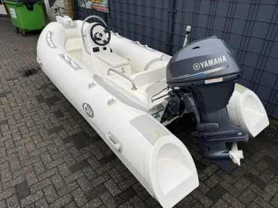 witte rubberboot met buitenboordmotor