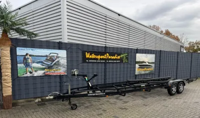 tandemasser trailer geparkeerd bij bedrijfswand