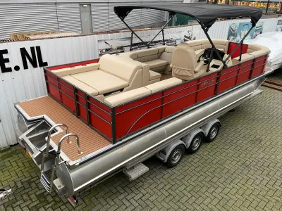 Rode pontonboot op trailer bij opslaggebouw