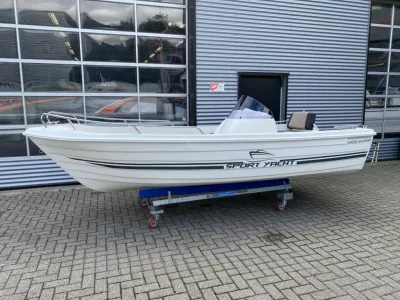 witte sportboot op kar voor bedrijfsgebouw