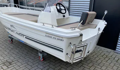 witte sportboot op trailer bij gebouw